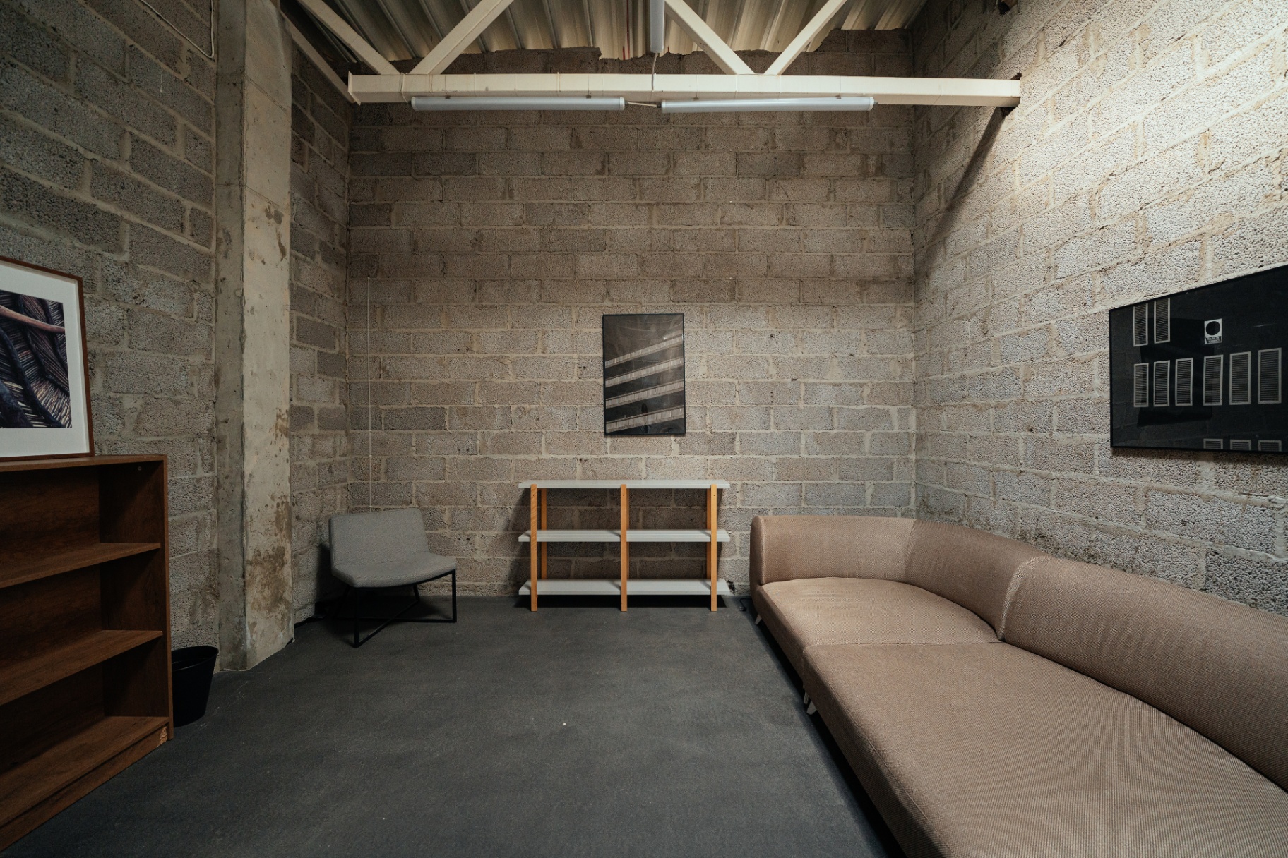 Second floor green room with long sofa, shelving and framed art