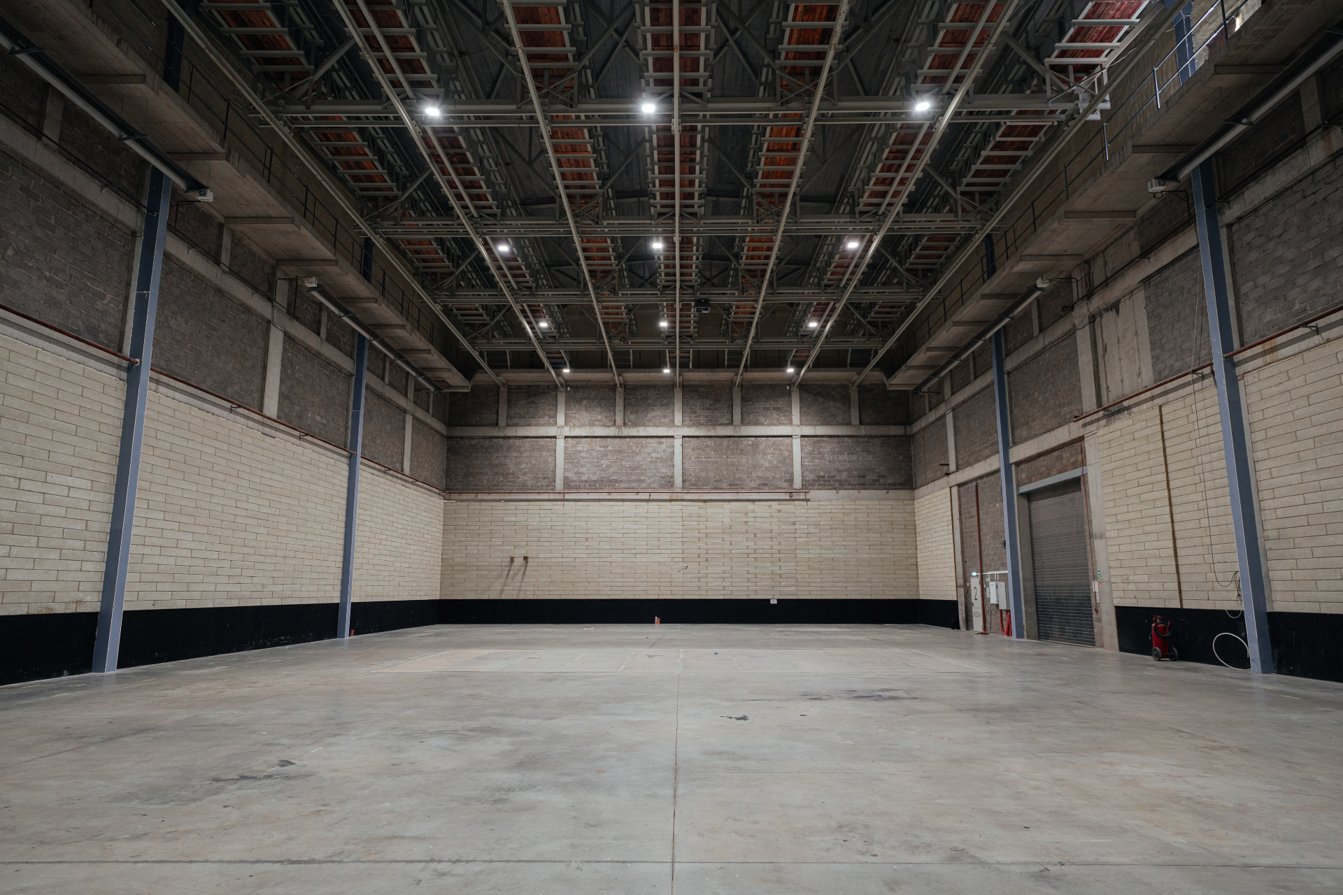 Studio 1 interior with high ceiling rigging grid and open concrete floor